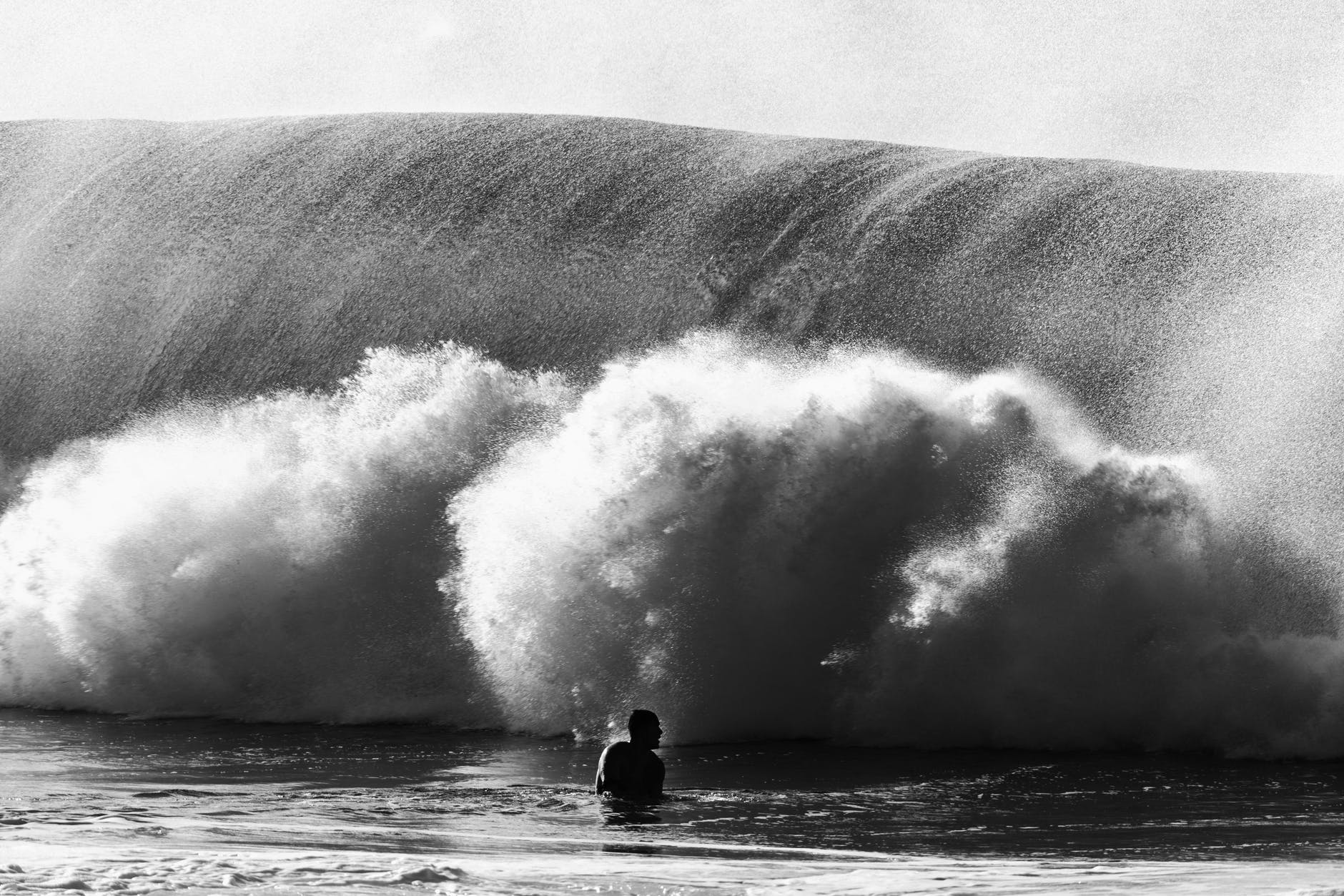 silhouette of anonymous man near wave